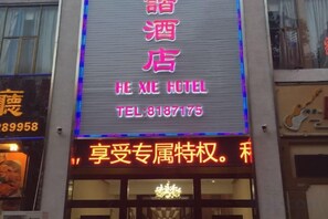 Hotellin kyltti, jossa lukee »HE XIE HOTEL» ja on ilmoitettu puhelinnumero.