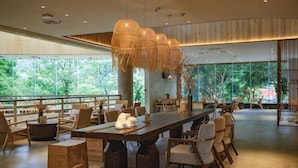 A spacious indoor area with a long table, chairs, and hanging light fixtures. - Sky & Sea Resort (Chongqing)