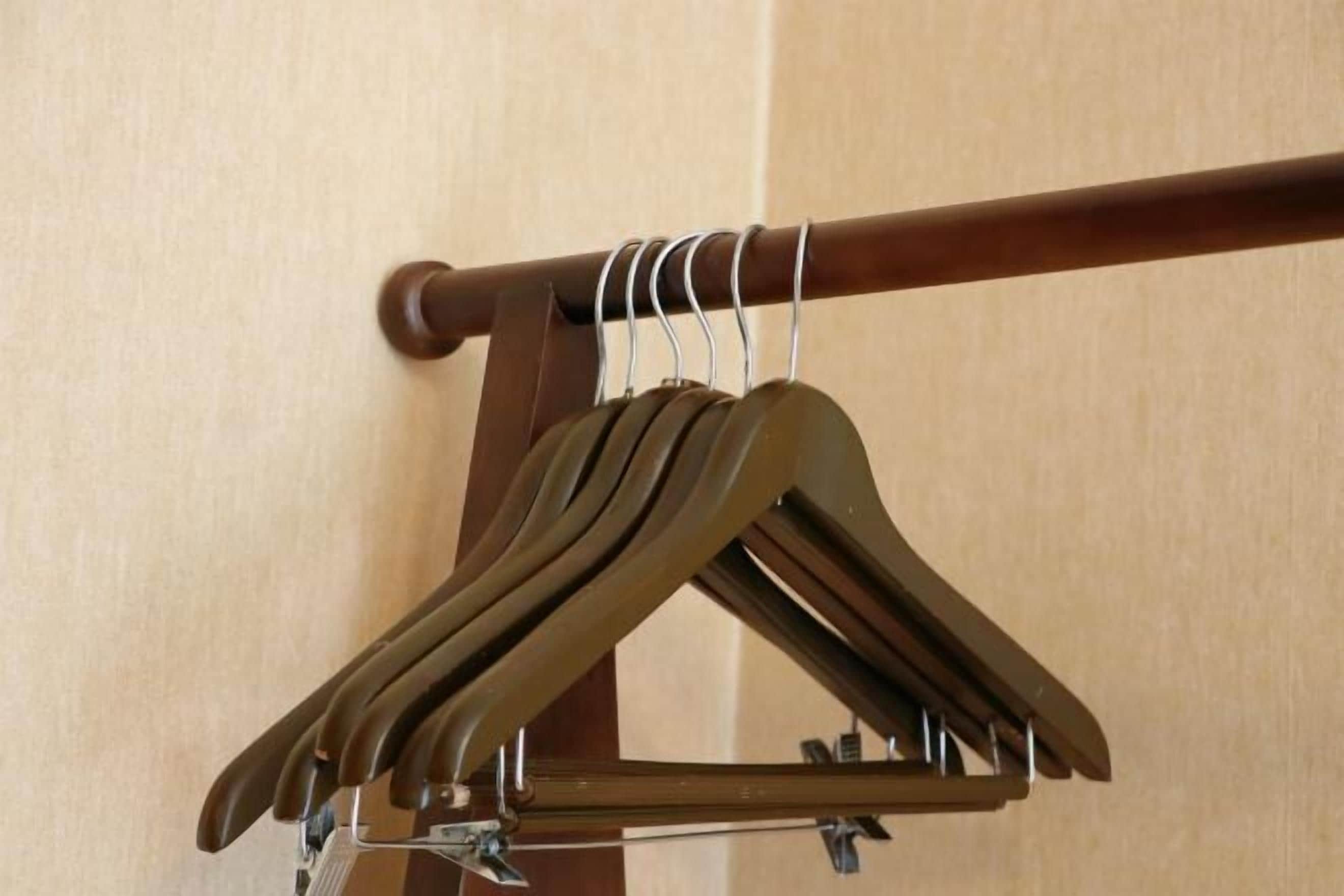 Um porta-roupas de madeira com vários cabides.