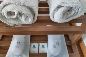 A wooden rack with folded towels and a set of slippers. - Sky Sea Resort (Chongqing)