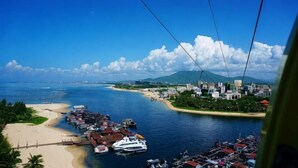 A coastal cityscape with a marina, boats, and a beach. - Lingshui Sancai Business Hotel (Lingshui)