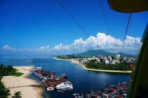Un paisaje urbano costero con un puerto deportivo, barcos y una playa.