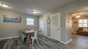 A dining area with a wooden table and chairs, a ceiling light, and a wall with a motivational quote. - Spacious 3BR in Phoebus - Great Monthly Rates (Hampton)
