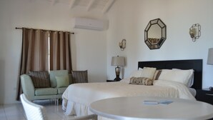 Una habitación de hotel con cama, sofá, mesa redonda y lámpara.