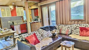 Uma sala de estar aconchegante com um sofá, uma mesa pequena e um cão.