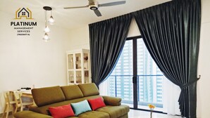 A modern living room with a sofa, a round coffee table, and a ceiling fan. - The OakHome Lakecity @ KL Taman Wahyu 3-bedroom Poolview! (Batu Caves)