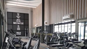 A modern gym with various exercise equipment, a large motivational wall, and large windows allowing natural light. - The OakHome Lakecity @ KL Taman Wahyu 3-bedroom Poolview! (Batu Caves)