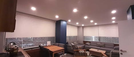 A compact living space with a kitchenette, dining area, and seating area.