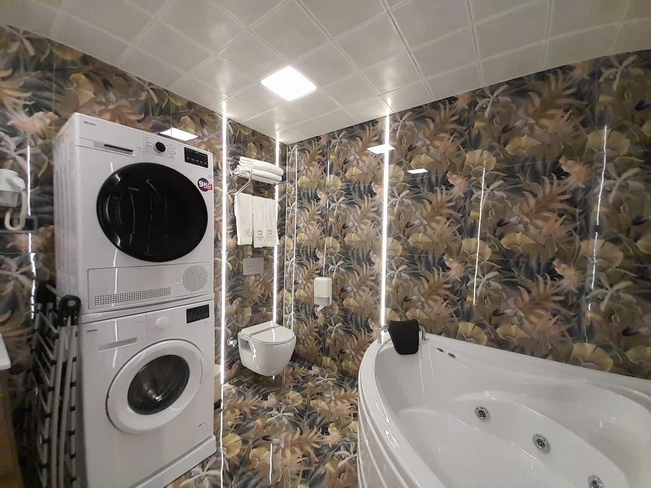 Un baño con lavadora, inodoro y bañera.