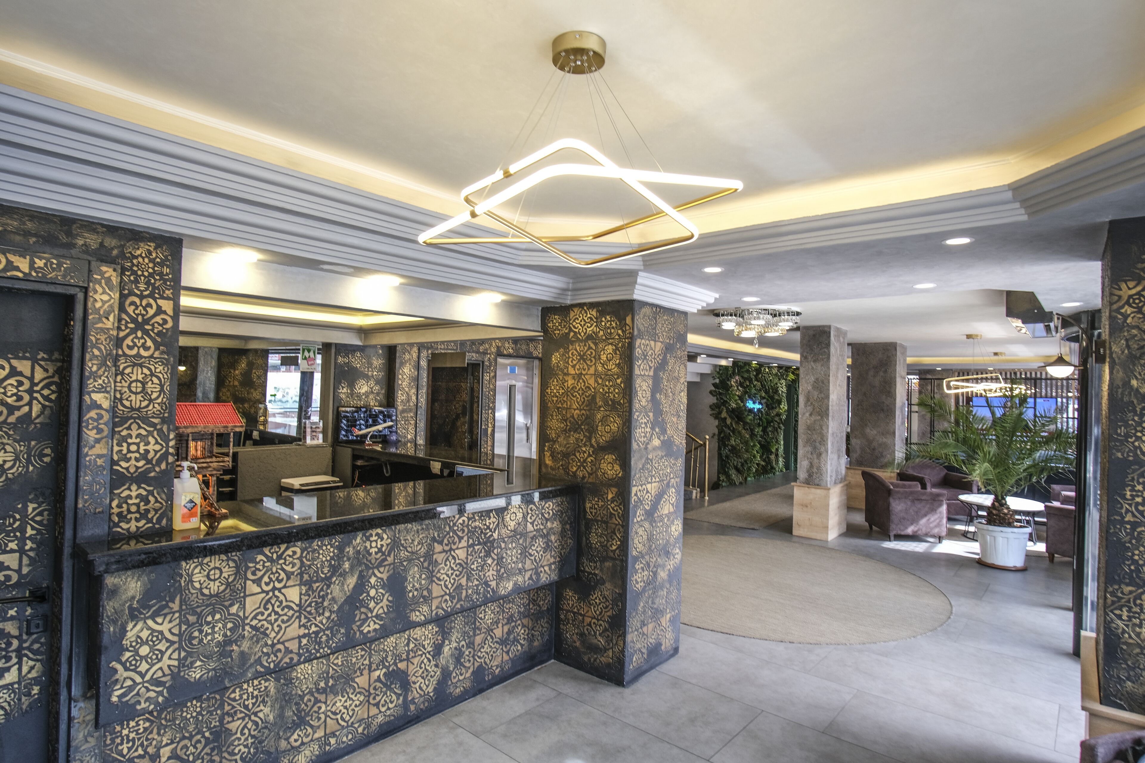 Un vestíbulo con paredes decoradas, mostrador de recepción y zonas de estar.