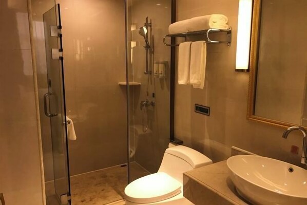 A modern bathroom with a glass-enclosed shower, a toilet, and a sink with a mirror. - Vienna Hotel (Ji'an County Yanjingfu) (Ji'an County)