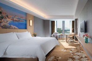 A hotel room with a large bed, a desk, a chair, a TV, and a painting on the wall. - Vienna Hotel (Ji'an County Yanjingfu) (Ji'an County)