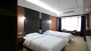 A hotel room with two beds, a desk, a chair, and a large window with curtains. - Yi Xiao Ting Hotel (Enshishi)