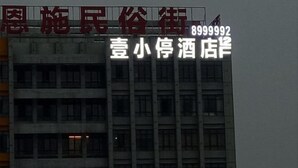 A building with a sign that reads "Liu Xiaofeng Hotel" and a phone number "8999992". - Yi Xiao Ting Hotel (Enshishi)
