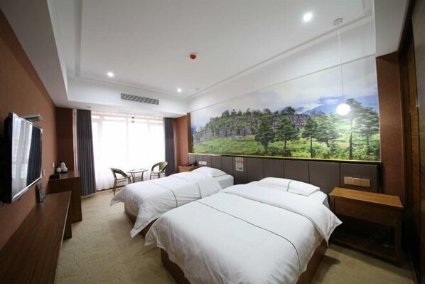 A hotel room with two beds, a TV, a desk, and a window with a scenic view. - Yi Xiao Ting Hotel (Enshishi)