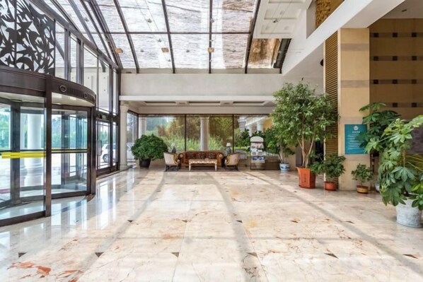 A spacious lobby with a marble floor, a bench, potted plants, and a glass entrance. - Tianhaoyuan Country Club (Beijing)