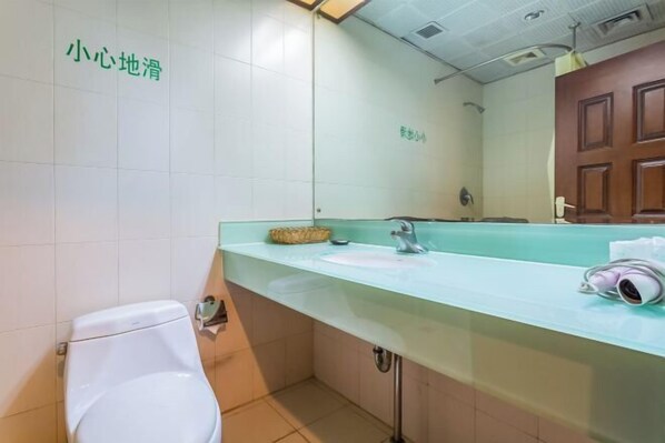 A bathroom with a white toilet, a sink with a mirror, and a towel dispenser. - Tianhaoyuan Country Club (Beijing)