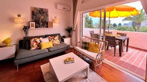 Una sala moderna con un sofá, una mesa de centro y un comedor con una mesa y sillas.