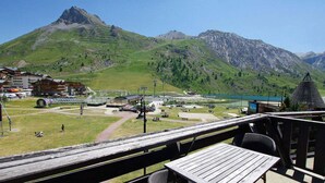 A mountain resort with a ski lift, a lake, and a view of the surrounding mountains.