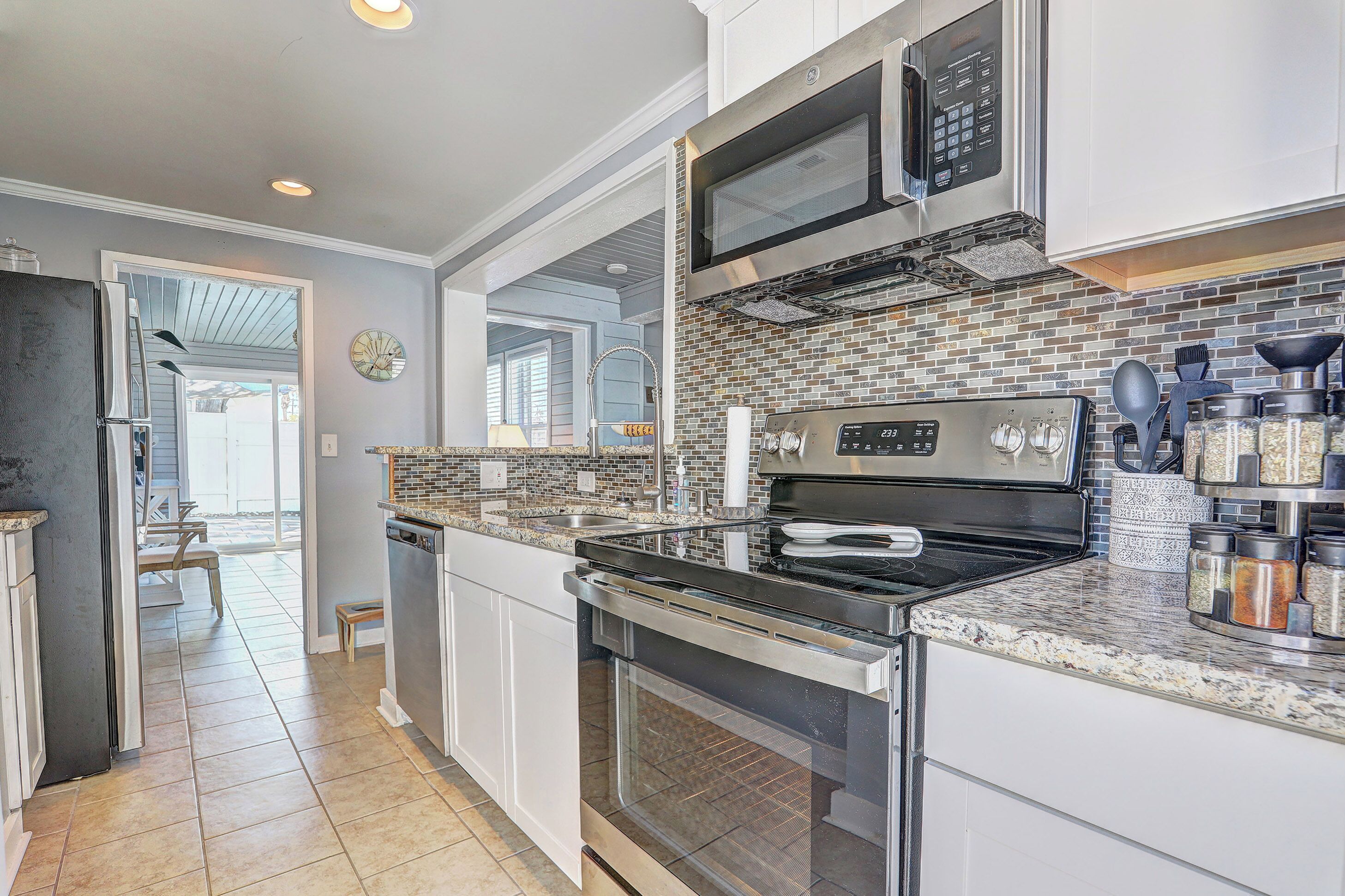 A modern kitchen with a stainless steel range, microwave, and oven.