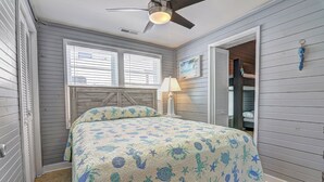 A bedroom with a bed, a ceiling fan, and a window with blinds. - Cottage on the Rocks - 3 Bedrooms - Walk to Beach - Outdoor Seating - Pet Friendly (North Myrtle Beach)