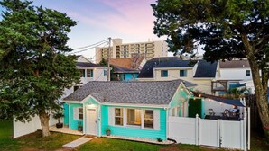 A single-story house with a gabled roof, a front porch, and a fenced backyard. - Cottage on the Rocks - 3 Bedrooms - Walk to Beach - Outdoor Seating - Pet Friendly (North Myrtle Beach)