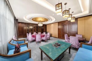 A hotel lobby with a round table, blue sofas, and a green coffee table. - Hanwu International Hotel (Wuwei Pedestrian Street Branch) (Wuwei)