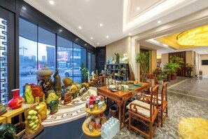 Een lobby met een groot raam, een receptiebalie en diverse decoratieve objecten.