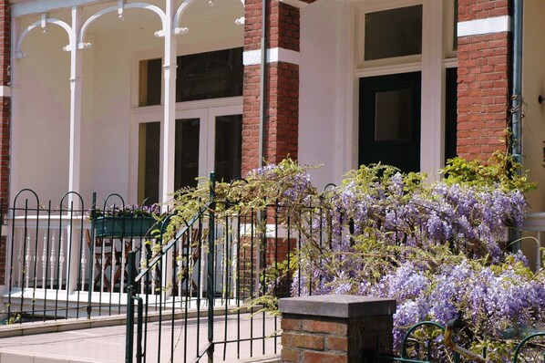 A building with a brick facade, white columns, and a black door.