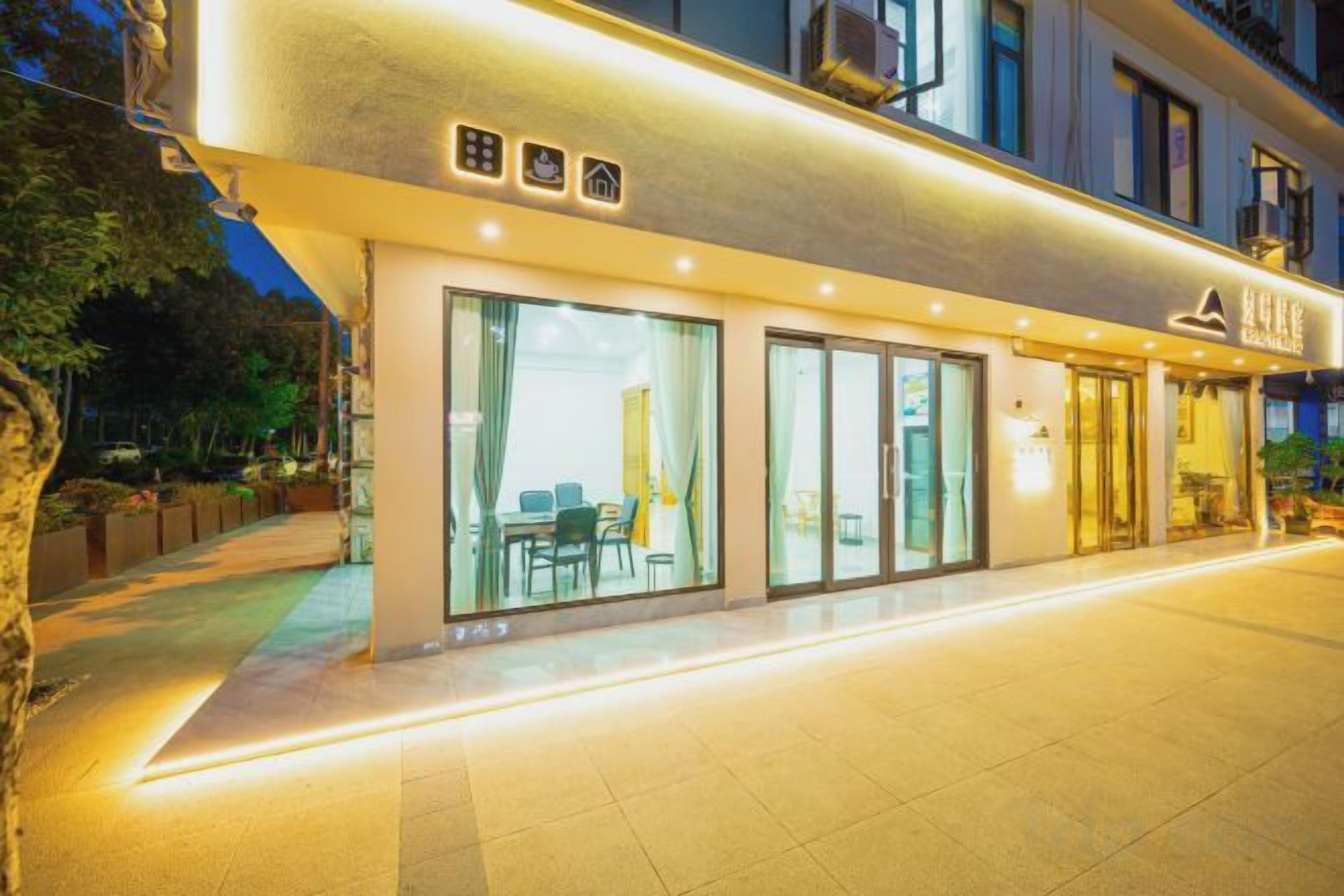 A hotel with a modern facade, large glass windows, and a well-lit entrance.