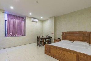 A bedroom with a wooden bed, a small table, a chair, and a window with curtains. - Jiangdao Hostel (Jiangmen)