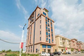 A multi-story hotel with a central tower and a flat-roofed structure. - Jiangdao Hostel (Jiangmen)