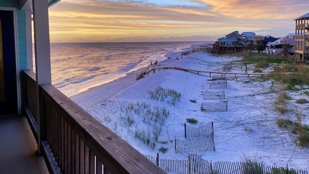 A beach view from a balcony with a wooden railing, sandy beach, and a wooden walkway leading to the water. - 4 Bed/3 Bath North Cape San Blas Beach Front Home - Steps to the Water!! (Port St. Joe)