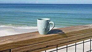 A wooden deck with a white mug on it, overlooking a calm sea and clear sky. - 4 Bed/3 Bath North Cape San Blas Beach Front Home - Steps to the Water!! (Port St. Joe)