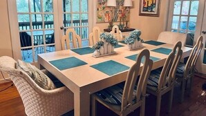 Une salle à manger avec une grande table, des chaises et un lustre.