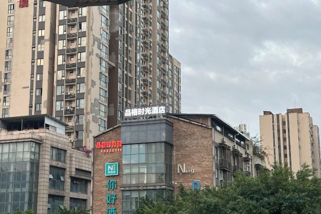 Un edificio de varios pisos con un letrero que indica un comercio en la planta baja.