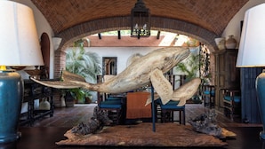 Um hall com uma grande escultura de baleia, arcos de tijolo e um candelabro.