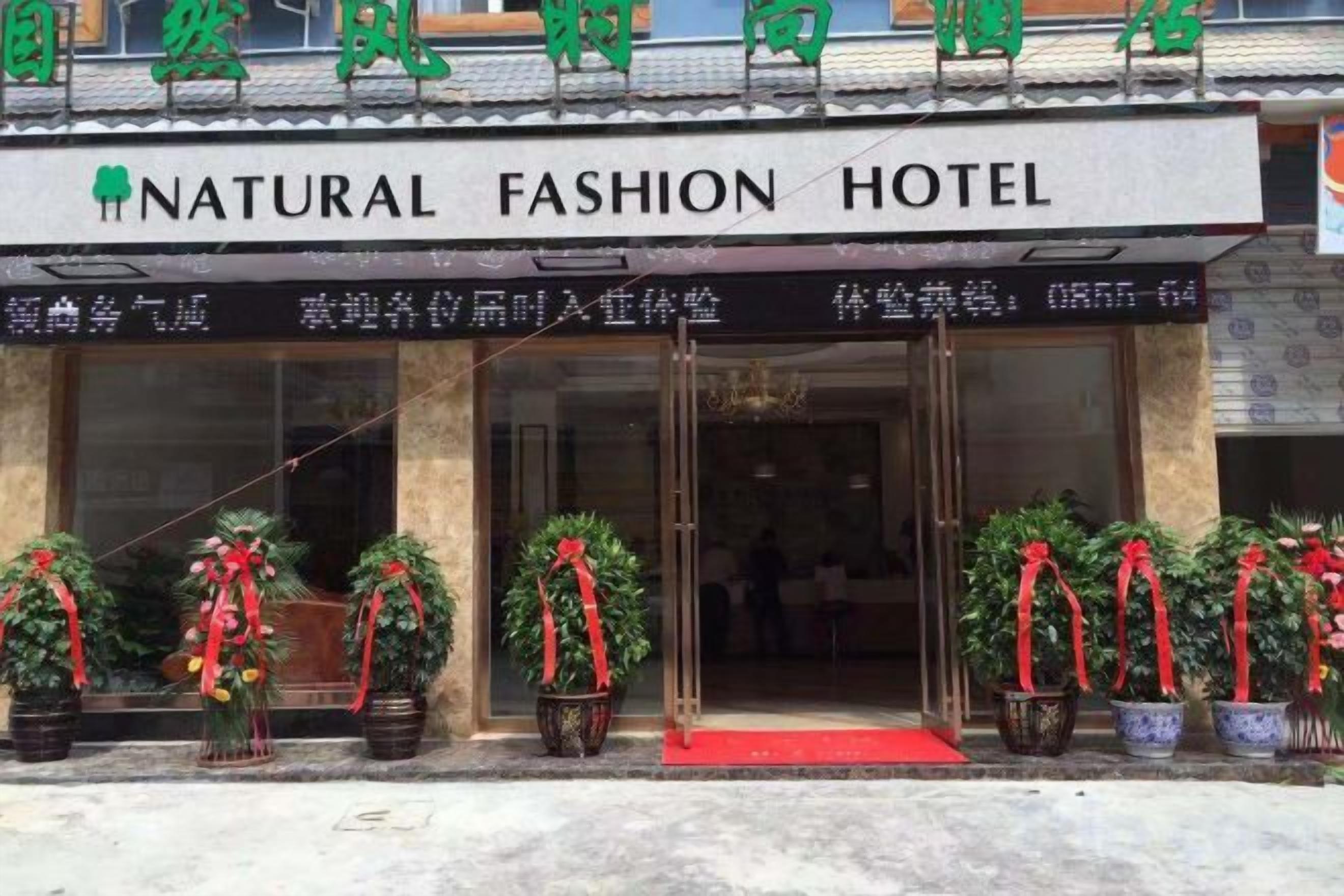 Een hotelentree met een bord waarop staat 'NATURAL FASHION HOTEL'.
