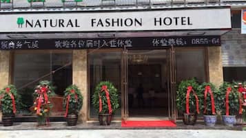 A hotel entrance with a sign reading 'NATURAL FASHION HOTEL.'