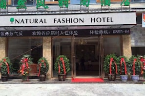 L’entrée d’un hôtel, avec une enseigne indiquant : « HÔTEL DE LA MODE ÉCOLOGIQUE ».