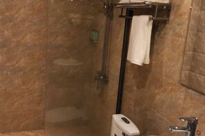 A bathroom with a glass-enclosed shower, a white towel hanging on a rack, and a soap dispenser on the sink. - Ziranfeng Fashion Hotel (Congjiang Food Street) (Congjiang)