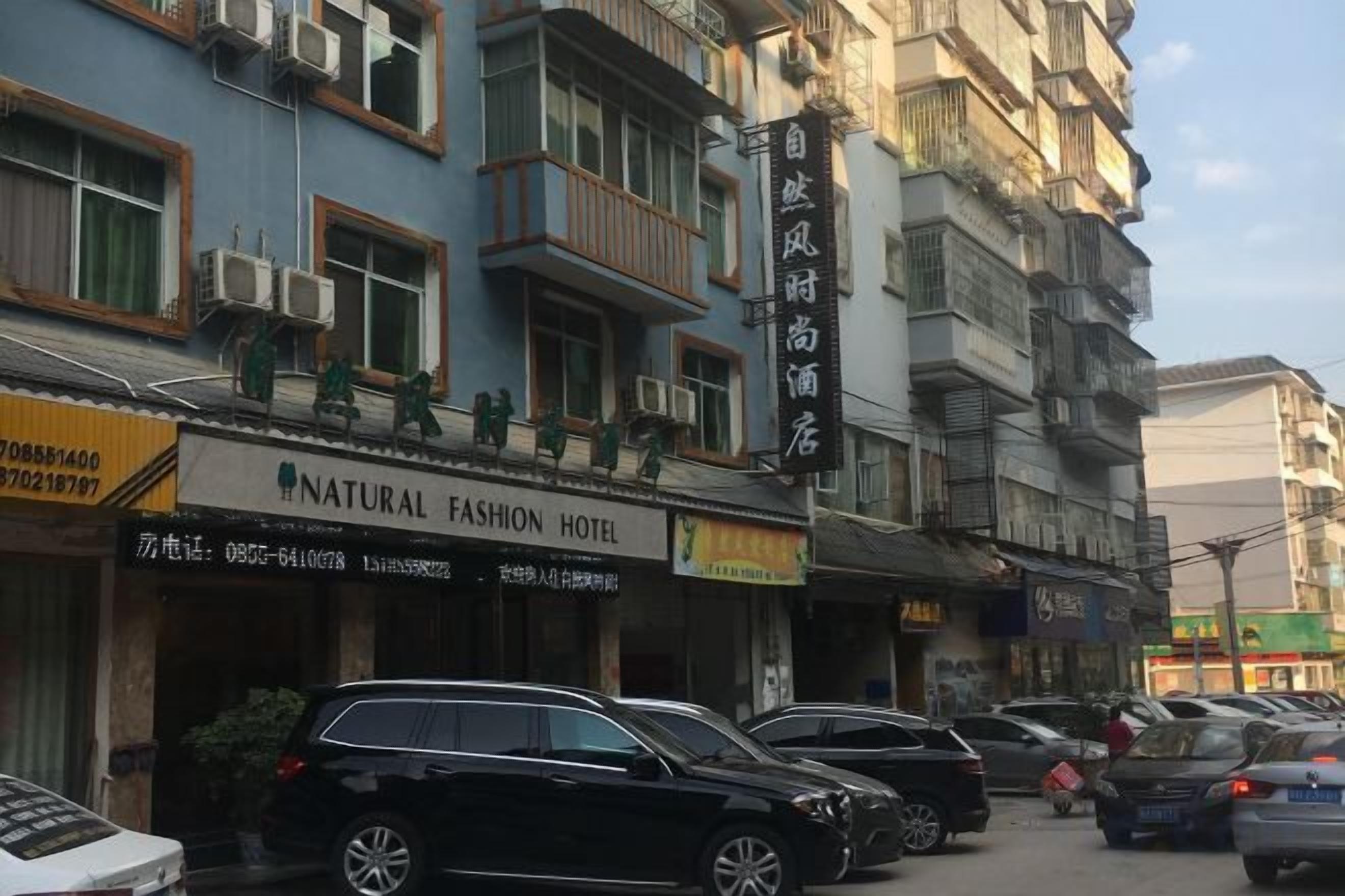 Ein Hotel mit mehreren Etagen, Balkonen und einem Schild für ein Naturmode-Hotel.