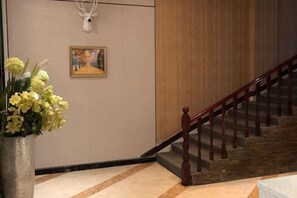 Eine Treppe mit hölzernen Geländern und einem an der Wand befestigten Hirschschädel-Dekoration.