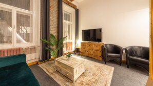 A living room with a sofa, a coffee table, a TV, and a cabinet. - S42 Hotel Prague (Prague)