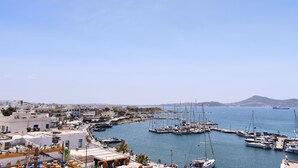 A marina with boats docked, buildings in the background, and a clear sky. - Mariet Naxos Elegant Suites (Naxos)