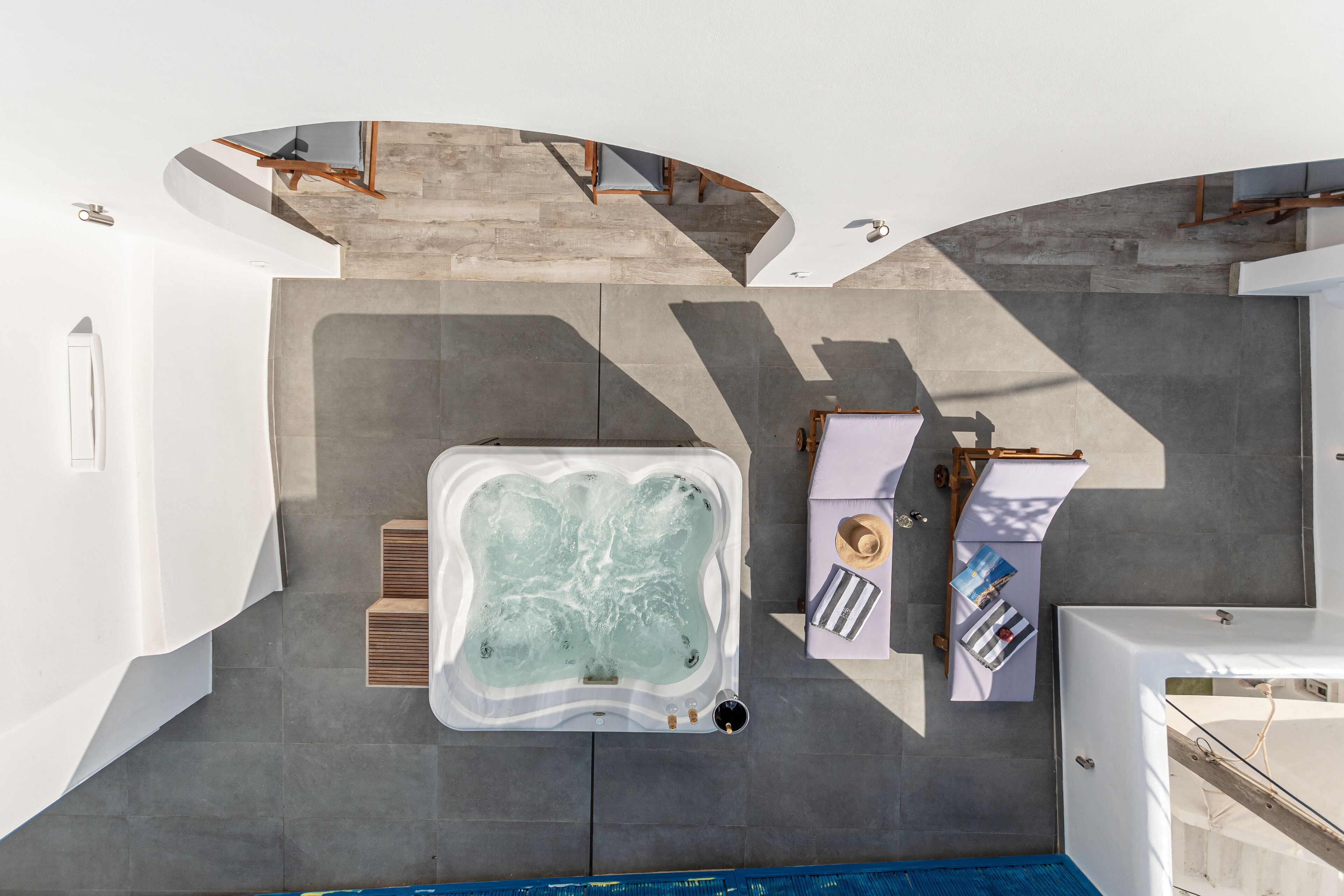 A modern bathroom with a large bathtub, a shower area, and a seating area with a table and chairs.