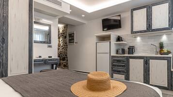 Una cocina moderna con refrigerador empotrado, microondas y televisor de pantalla plana.