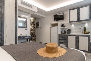 Una cocina moderna con refrigerador empotrado, microondas y televisor de pantalla plana.