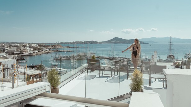 A terrace with a view of a marina, boats, and a distant mountain. - Mariet Naxos Elegant Suites (Naxos)