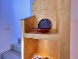 Una escalera con un estante decorativo que sostiene un cuenco y un plato.